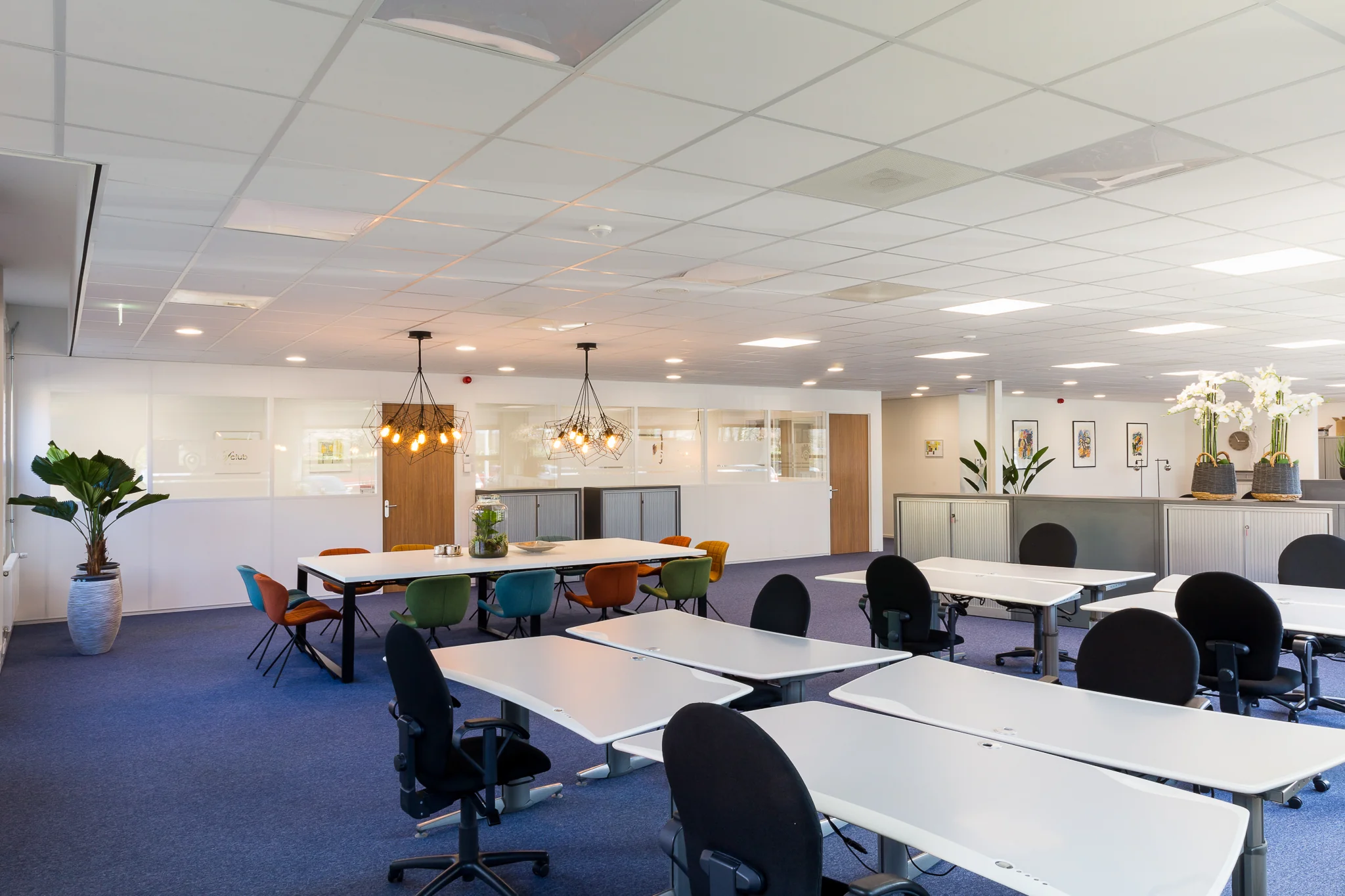 Moderne, open kantoorruimte aan de Niels Bohrweg met flexwerkplekken, vergadertafels en kleurrijke stoelen.